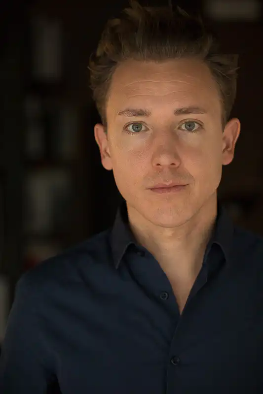 Portrait von einem jungen Mann vor dunklem Hintergrund - Fotograf UNIKATUM